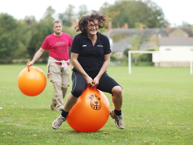 Teams take part in the annual Geddington Trundle Race by crossing an obstacle course with their barrel and spacehoppers. 2011