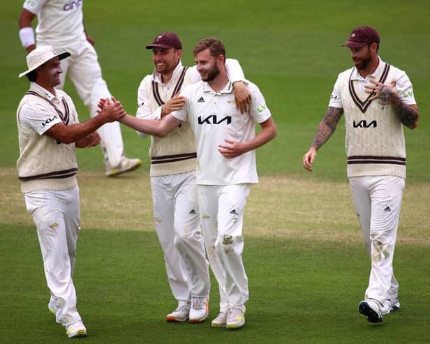 Gus Atkinson of Surrey celebrates with team mates after taking the keywicket of Luke Procter