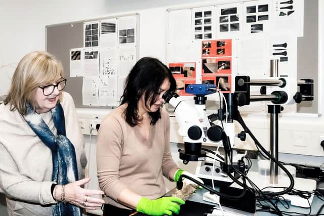 Carol Fitzgerald, left watches Dr. Christina Tsoraki, study the Higham Ferrers Flint axe