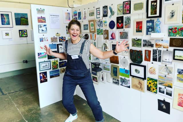 Katie Boyce standing in front of the Mini Masterpieces from a previous year