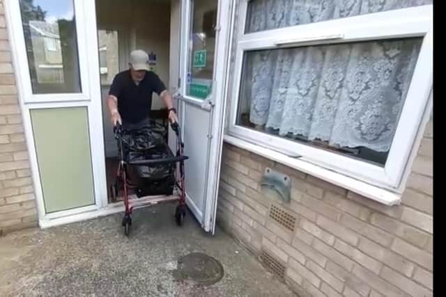 Tom Munro lifts his walker over the lip of the fire exit