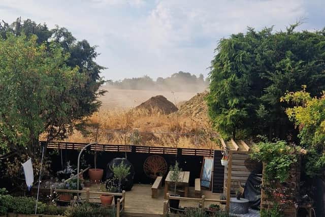 A cloud of dust rises from the pile