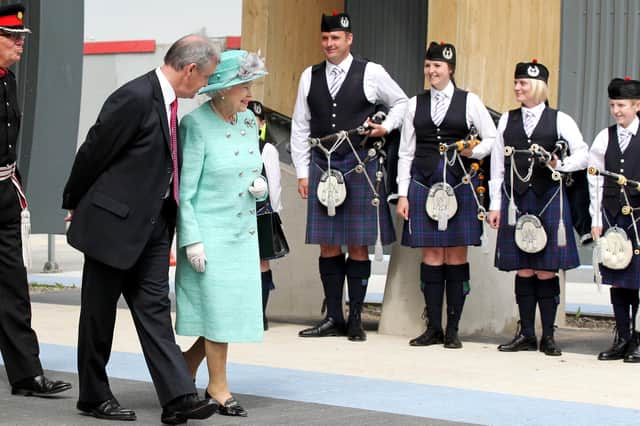 The Queen walks past the pipers from the Grampian Pipe Band