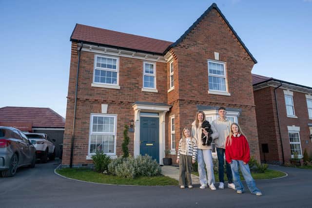 Aimee Fogg and her children outside their new home