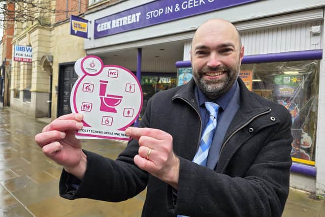 Cllr Lee Watkiss leader of Kettering Town Council with one of the signs indicating where people can access the loo/National World