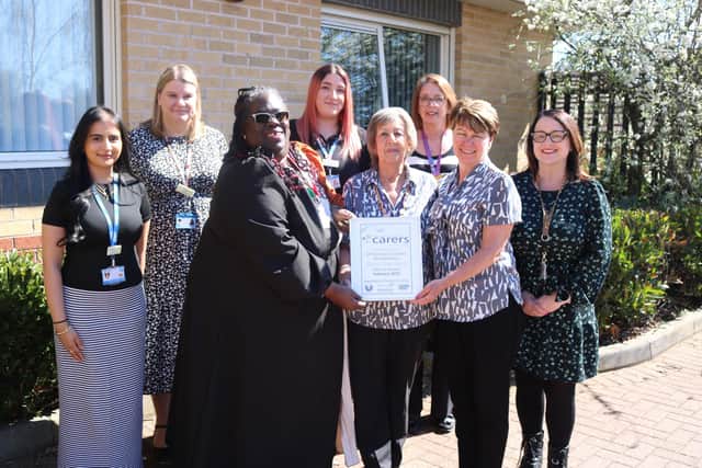 Carers Champions Christine and Marie, receiving the award from Jacqui Falconer-Blake, with colleagues including managers and members of the Social Prescribing team.