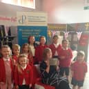 Cottingham C of E Primary School children join School Administrator, Carolynn Southcombe, as she is presented with her Silver Pearson Award.