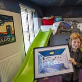 Jasper with his winning artwork in the bedroom designed by him