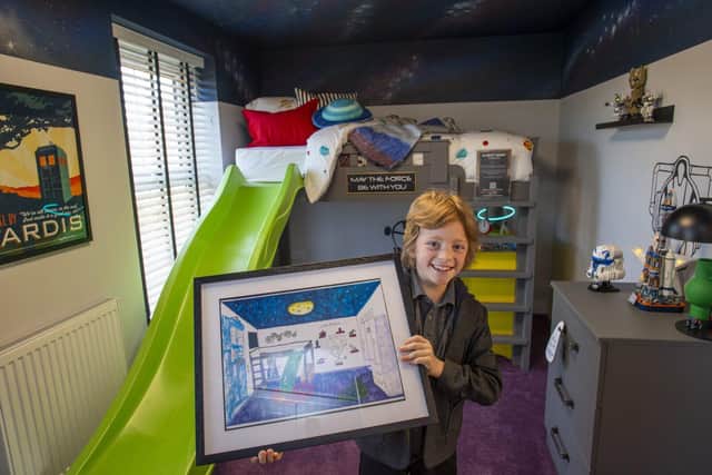 Jasper with his winning artwork in the bedroom designed by him