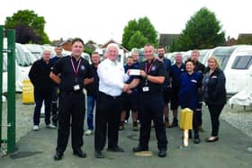 Andrew Scott (centre) hands over a cheque for £1,000 to Rob Berwick and Tony Evans of the Northamptonshire Fire Service.