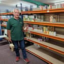 Chris Neilan with the bare shelves of Kettering Food Bank