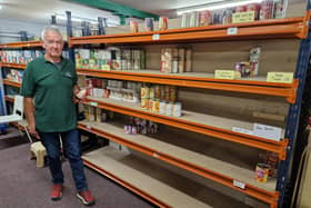 Chris Neilan with the bare shelves of Kettering Food Bank