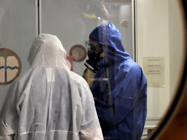 Dr Phil Watt enters the red zone filmed through a window in a connecting door at KGH during the pandemic.
