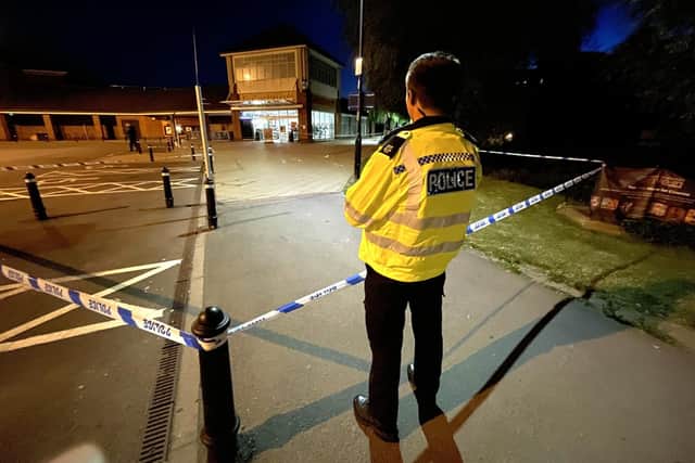 Officers protect the scene after the stabbing (photo by Andrew Carpenter)