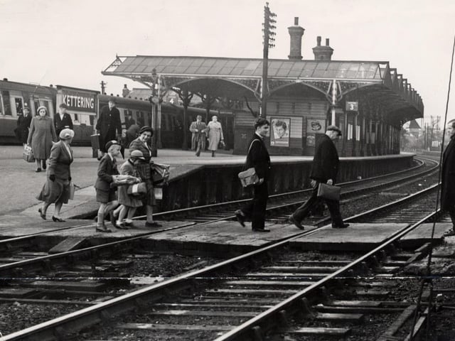 Passengers cross the tracks at Kettering station in 1954