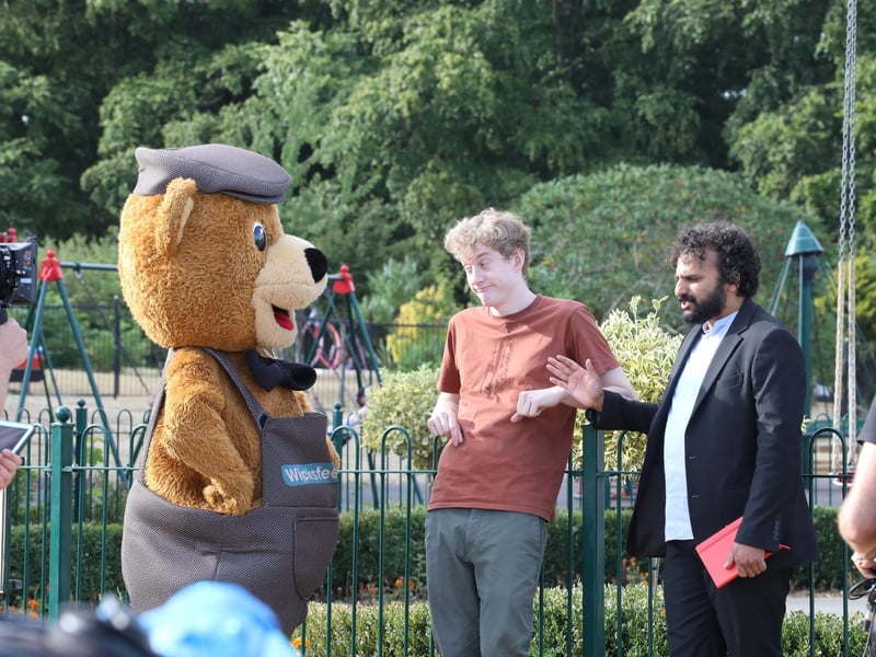 Nish Kumar and James Acaster filiming at Wicksteed Park with Wicky Bear and a goat named after James in August 2022.