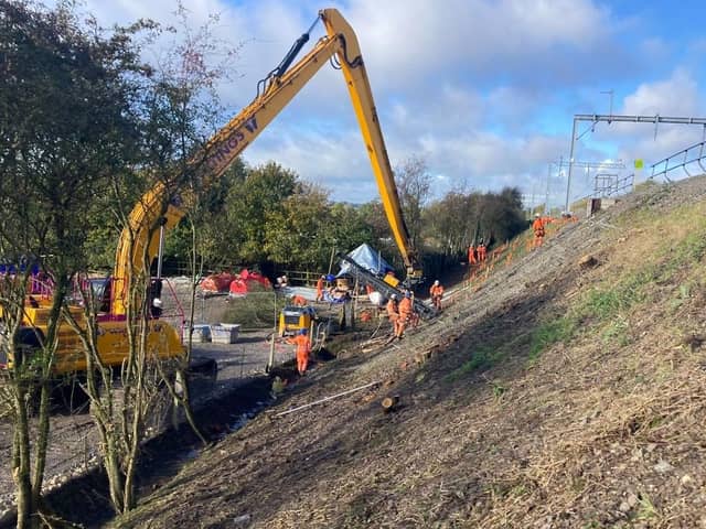 Engineers work on the unstable embankment that is under the track near Braybrooke