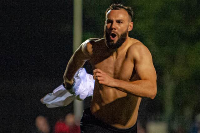 The shirt is off as Curtis Burrows heads off to celebrate his late, late winner for Corby