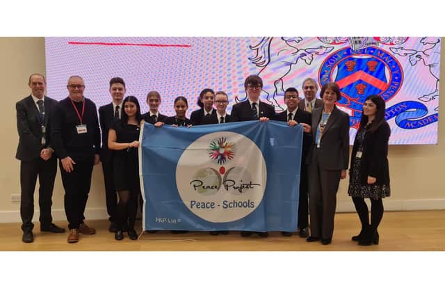Students and staff with the Peace Project Blue Flag