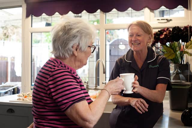 Homelium carer having tea with a client
