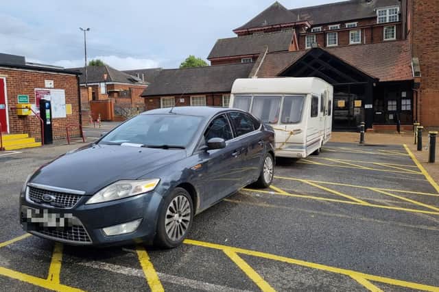 The car and caravan parked outside North Northamptonshire Council's offices in Bowling Green Road