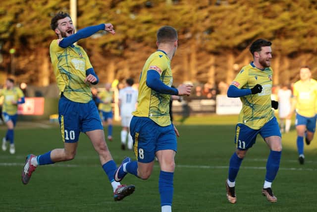 Will Jones (left) and Connor Tomlinson (right) rush to celebrate with Danny Draper after his stunning goal against AFC Rushen & Diamonds (Picture: Rob Webb)