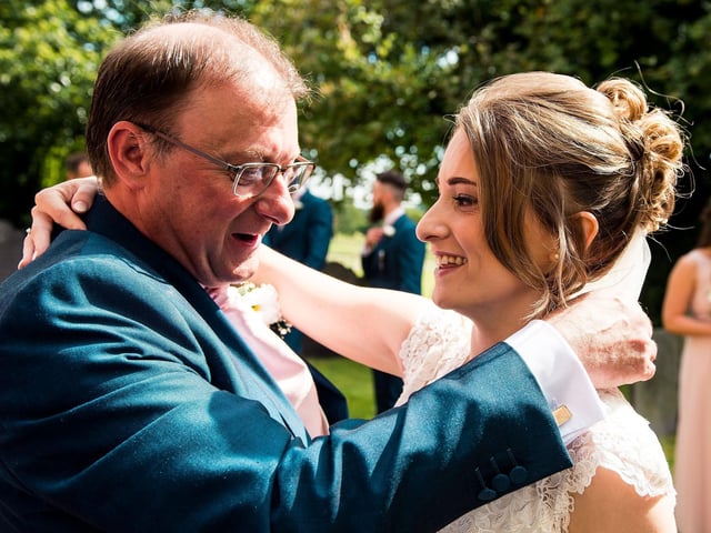 Kathryn and her father Kevin Abraham hug at her wedding in 2017.
