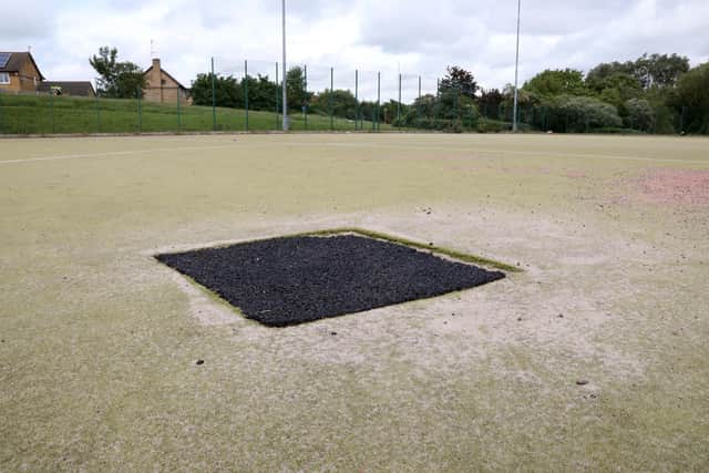 Areas of the pitch have been filled in with what appears to be play area rubber chippings.