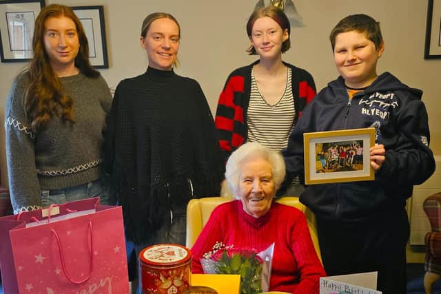 Elm Bank care home resident with the teachers and pupils of Stone Lodge Therapeutic School on her special day