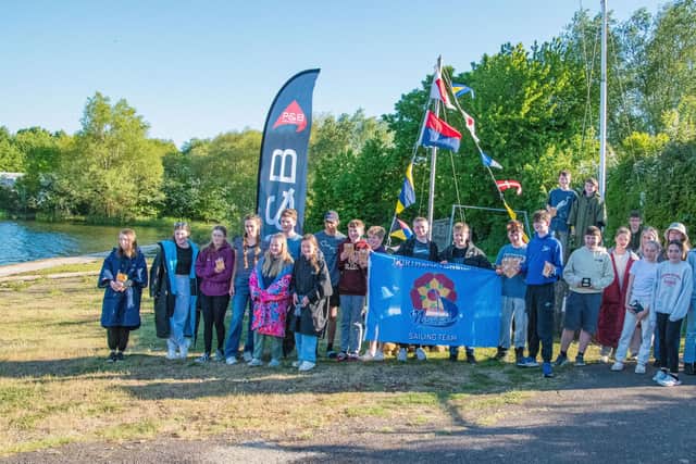 Twenty-five happy young sailors after a full day of sailing fun.