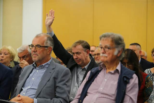 Mick Scrimshaw raises his hand at a meeting.