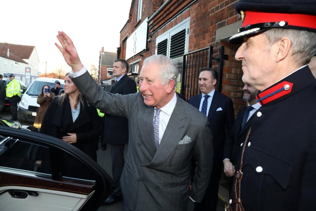 Prince Charles waves to well-wishers outside Gaziano & Girling in Balfour Street, Kettering