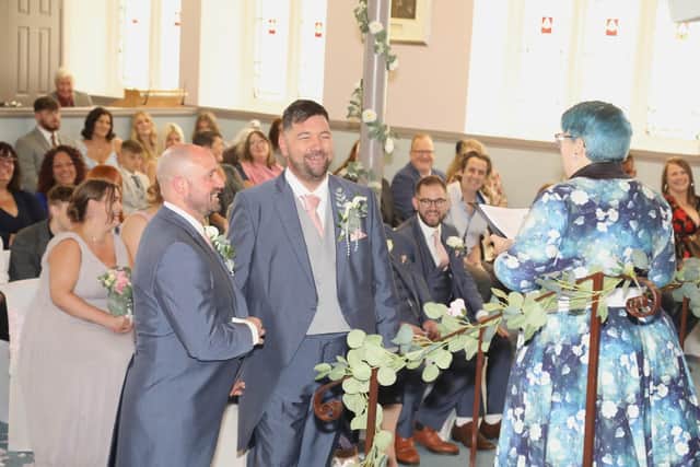 Dan Kimber and Ben Clarke standing in front of Rev Helen Wakefield-Carr at their wedding in the Toller Church, Kettering