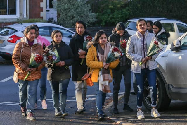 Staff from Kettering General Hospital where Anju Asok worked, arrive with flowers at the scene of the murders at Petherton Court, Kettering.  December 16, 2022. Image: Joseph Walshe / SWNS