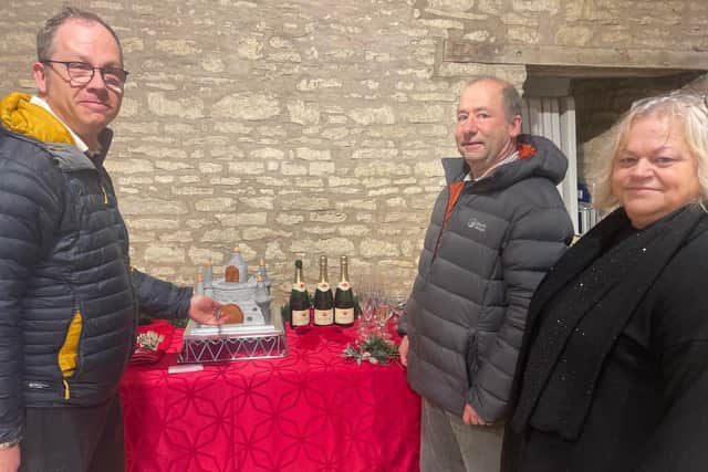 Olwen Mayes, right, chairman of HiFARS, commissioned a castle cake to celebrate the findings of the Higham Ferrers Castle research. Jeremy Cunnington, left, chairman of the Castle Studies Trustees, and Stephen Parry, lead archaeologist, were among the VIPs (Credit: Louise Parker)