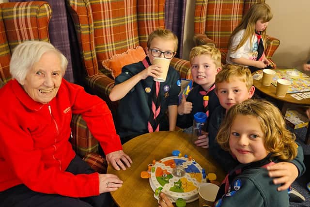 Young cubs with residents at Elm Bank care home playing traditional games to create festive fun for all.