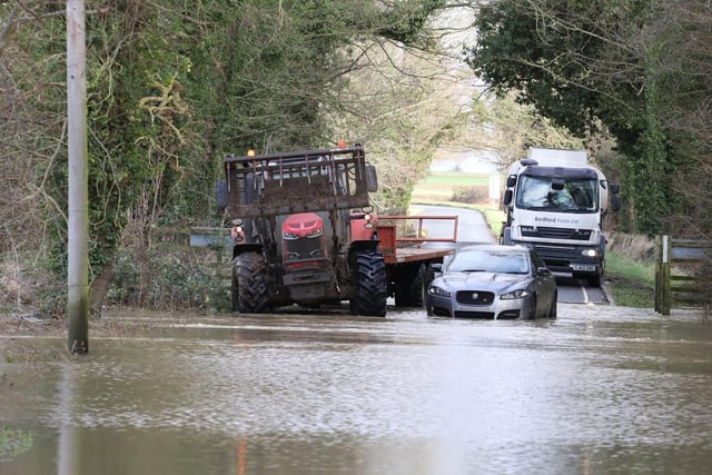 Fotheringhay - a flooded car sits in the water near Oundle