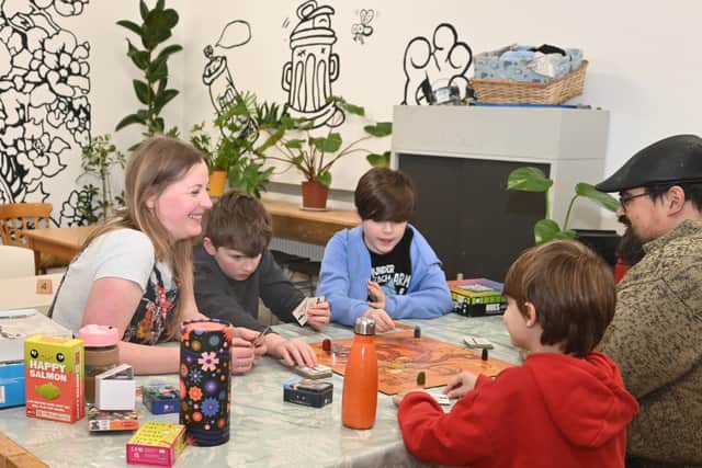 Polly Shackleton and Gavin Price playing board games with Rowan O'Malley and Eli and Finn Keller/Bok