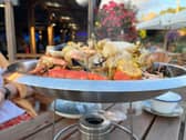 The Surf & Turf sharing bowl includes a roasted boil chicken, a whole lobster, crab, mussels, clams, smoked bratwurst and corn on the cob