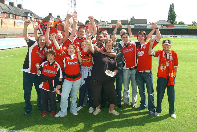 Kettering Town fans celebrate the 1-1 draw at the Poppies ground in their first league match with rivals Rushden and Diamonds August 2008