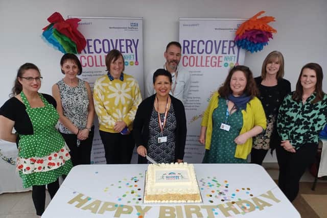 NHFT Chair Crishni Waring cuts the birthday cake alongside Nicola Oliver and the Recovery College NHFT team