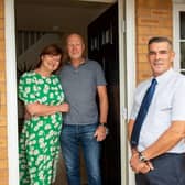 Gail and Garry outside their new home with site manager John