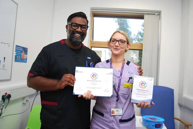 Healthcare assistant Ellie Silver is presented with her award by Prof Ganesh Baliah.