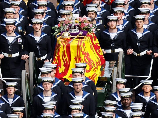 The Queen's funeral cortege borne on the State Gun Carriage of the Royal Navy travels along The Mall with the Gentlemen at Arms