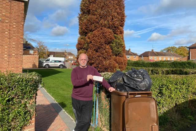 Christopher Kelly next to his bin