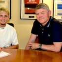 Keaton Ward puts pen to paper alongside Kettering Town manager Lee Glover. Picture courtesy of Poppies Media