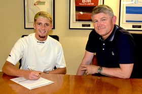 Keaton Ward puts pen to paper alongside Kettering Town manager Lee Glover. Picture courtesy of Poppies Media