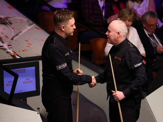Kyren Wilson shakes hands with John Higgins after the Kettering man was well beaten in the second round of the Cazoo World Championship