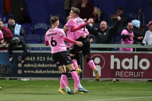 Northampton Town players celebrate their late equaliser at Mansfield Town.