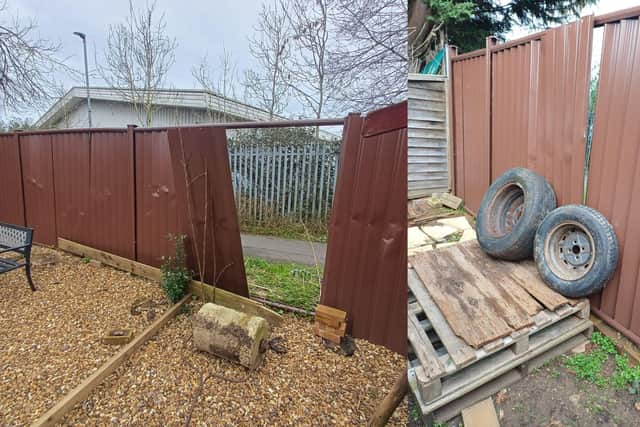 The metal fences have been propped up using wood pallets, tyres, and bricks